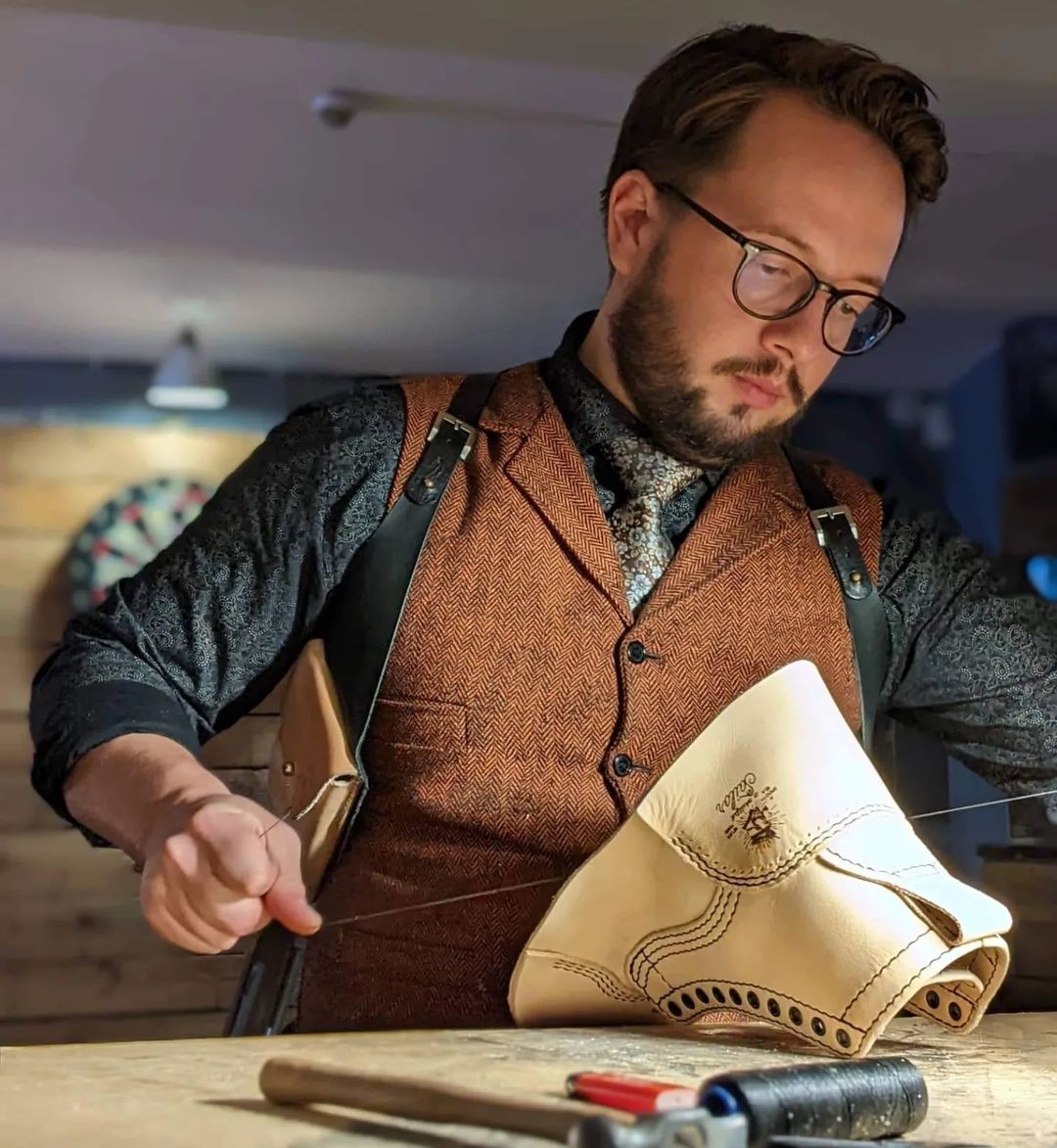 The maker behind R. Bents Handmade working with leather